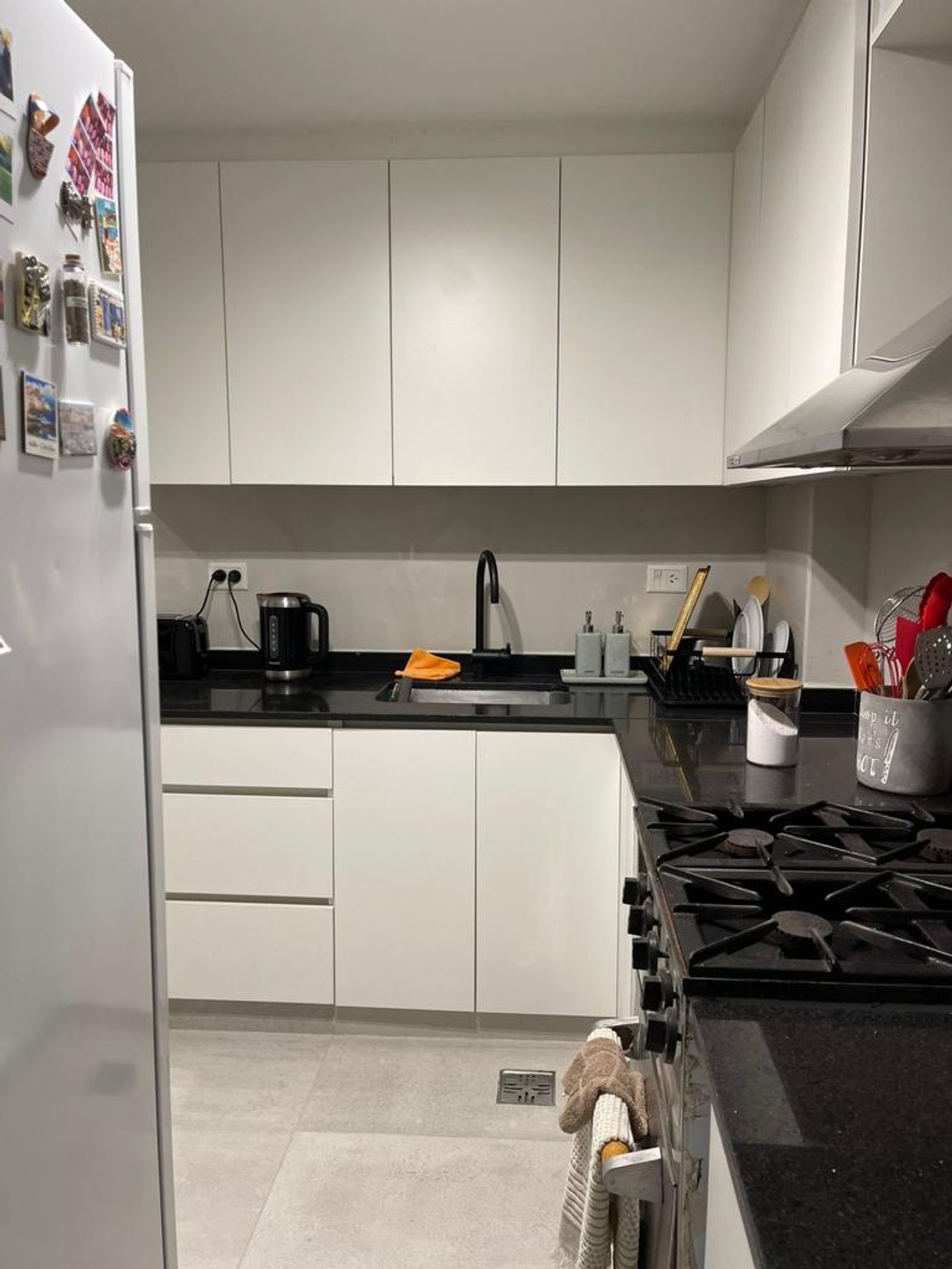 Cocina moderna con muebles blancos, mesadas negras y electrodomésticos — proyecto Olazabal, por Estudio NET Arquitectura , en Olazábal 3228