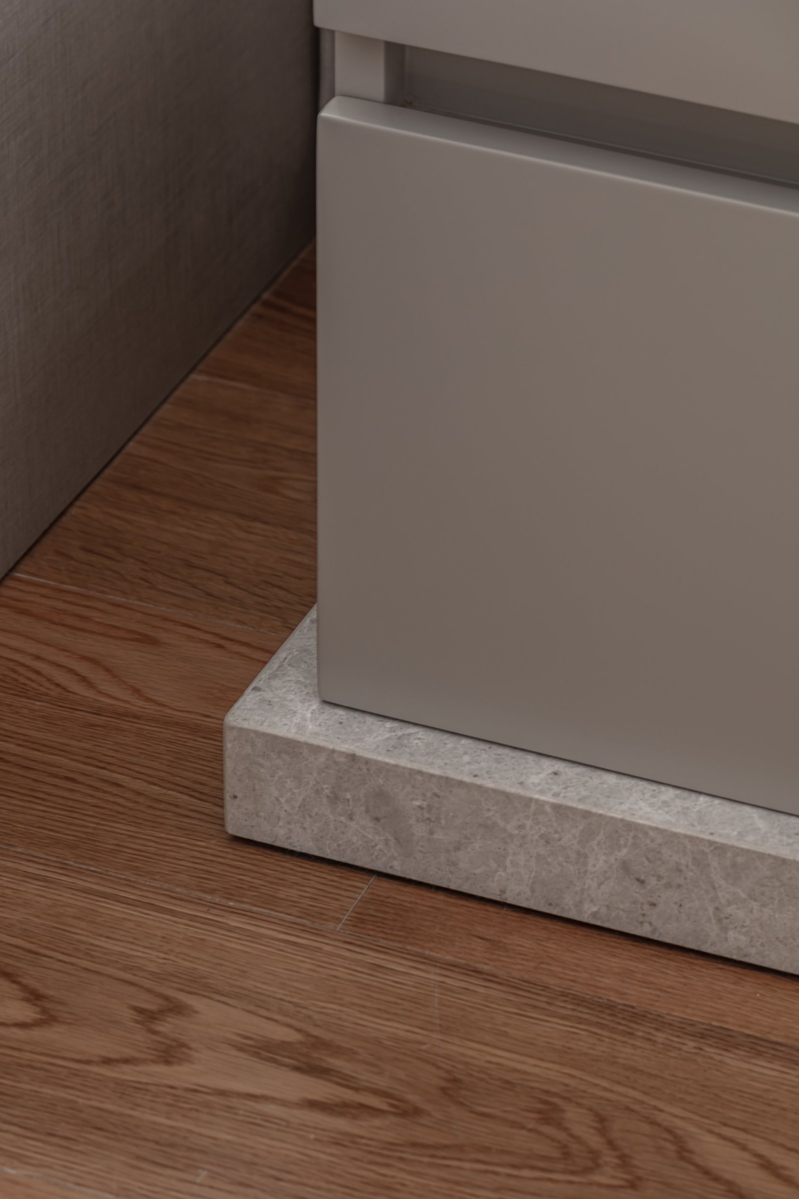 Mueble gris sobre base de piedra, piso de madera oscura — proyecto Donna Fiore | Sobrio & sofisticado | Sober & Sophisticated | Lucia Quinteros, por Ren Studio, en Provincia de Bue