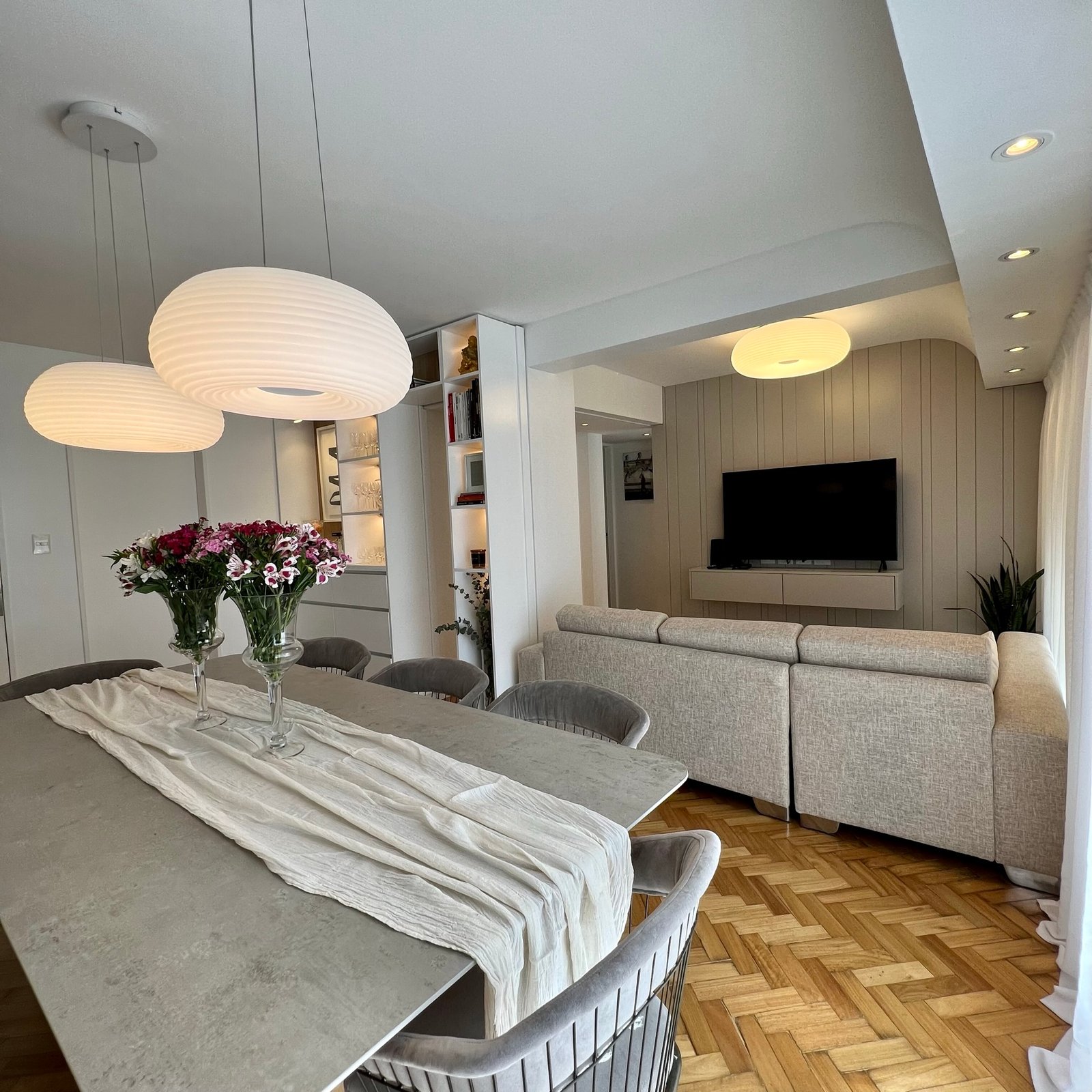 Comedor moderno integrado con living y luces colgantes — proyecto Cramer I, por MDBK Arquitectura, en Belgrano