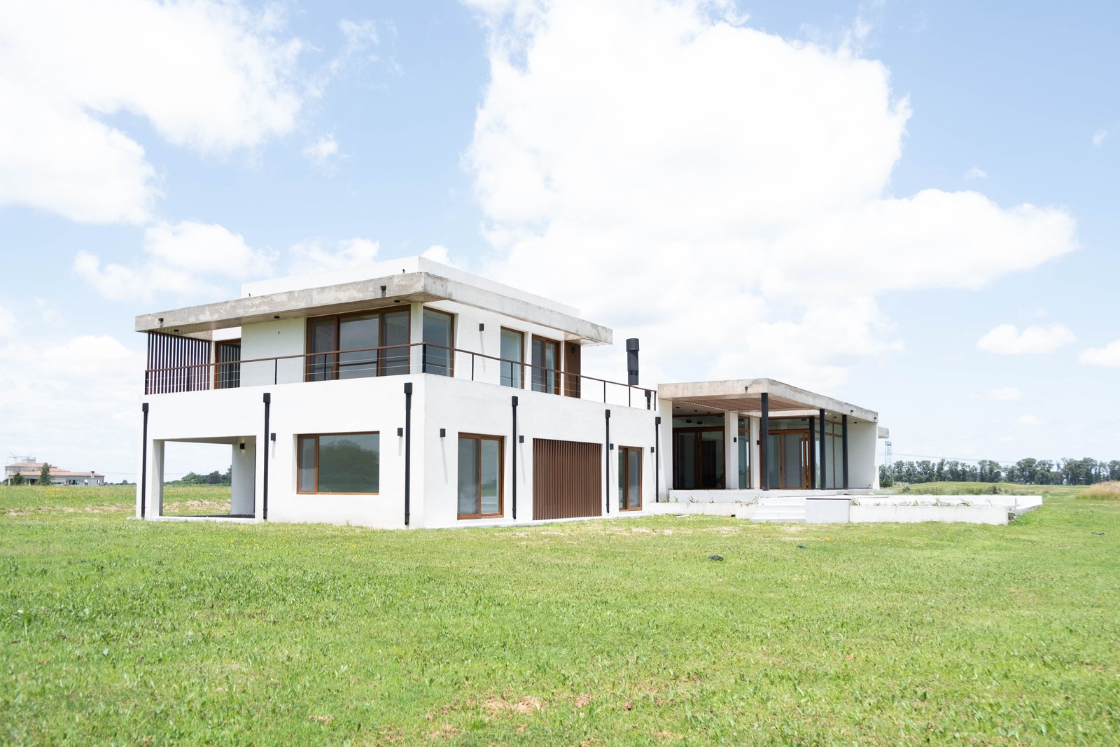 Casa moderna blanca con grandes ventanales y detalles de madera — proyecto CASA GOLF, por SEDE Arq., en Av. Pereda S/N