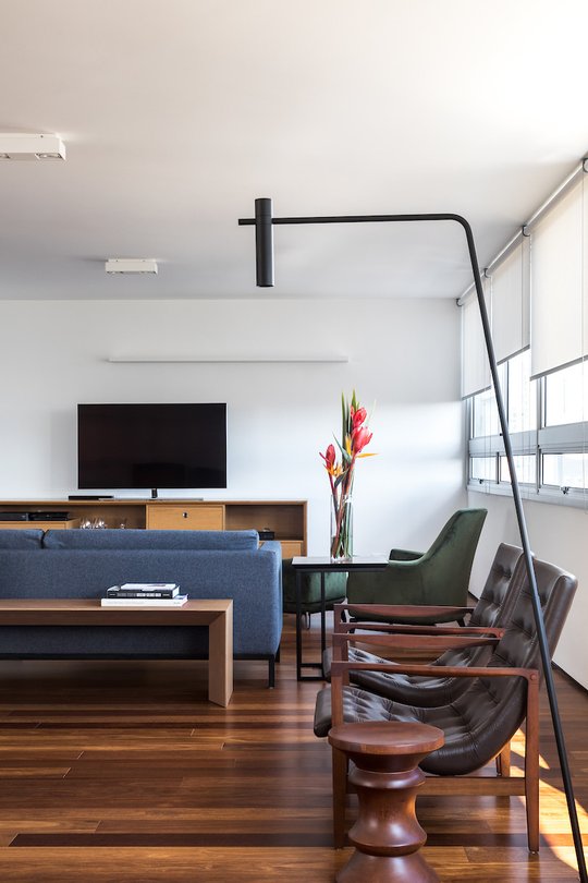 Amplio living comedor con sillones mid-century y lámpara de pie negra — proyecto Apartamento JB, por Boscardin Corsi Arquitetura