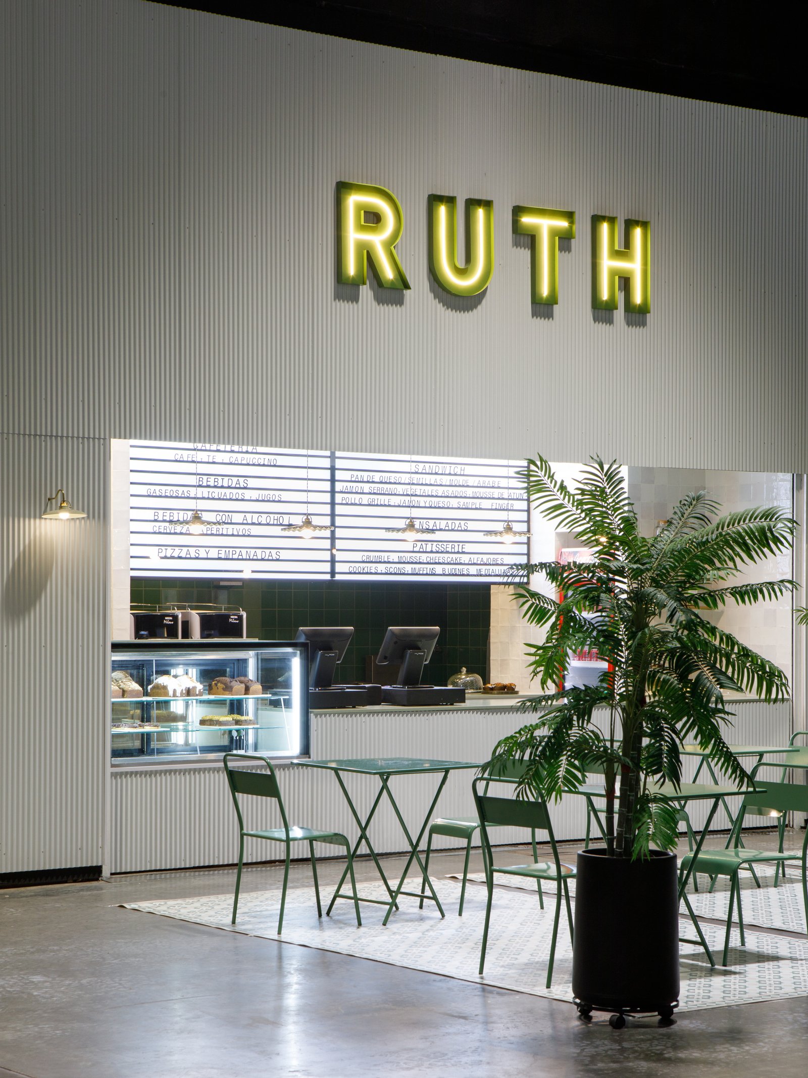 Local comercial minimalista con letrero de neón RUTH y mesas de bistro — proyecto RUTH La Rural, por Estudio Losa, en Juncal 4431