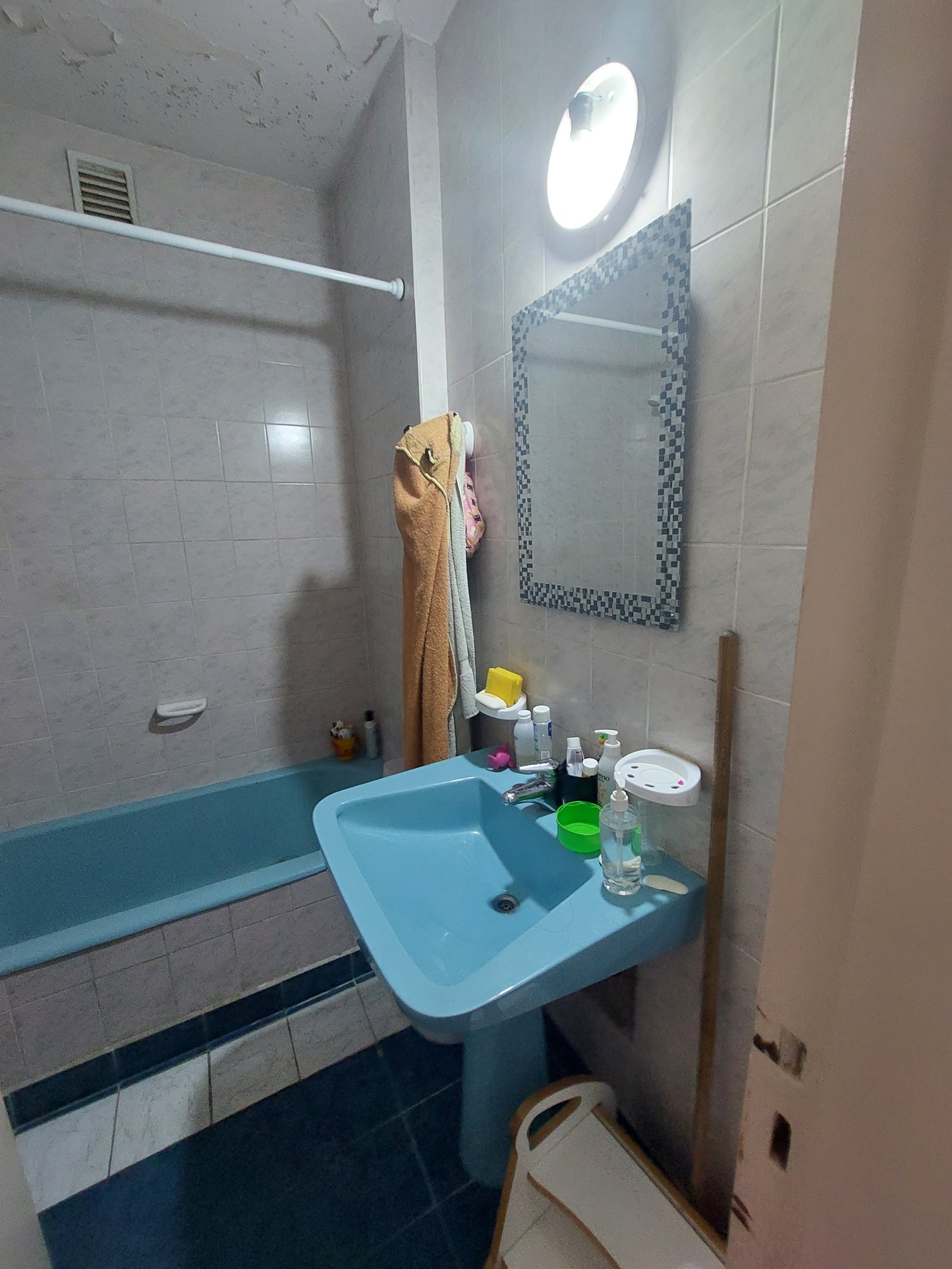 Baño con bañera y lavabo azules, paredes y suelo de azulejos — proyecto FLORES, por Arquitecta, en Flores