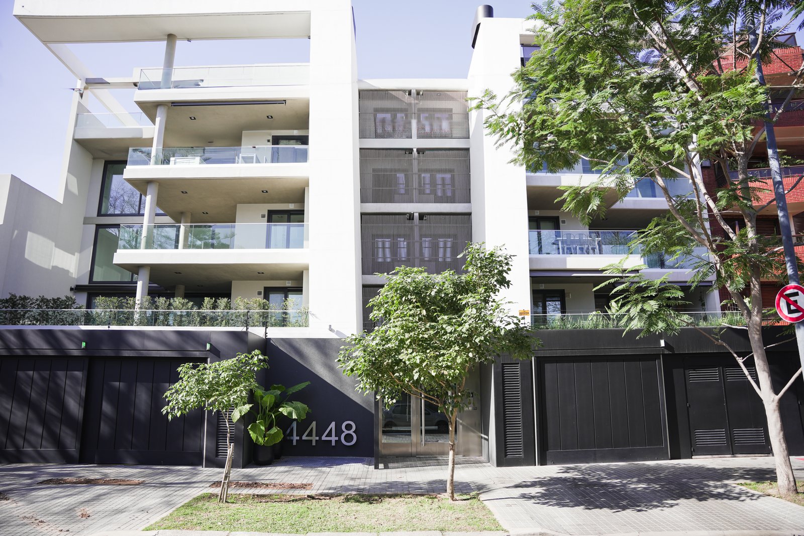 fachada moderna de edificio residencial blanco y negro — proyecto JLC Residences, por MUCHTEK, en Buenos Aires