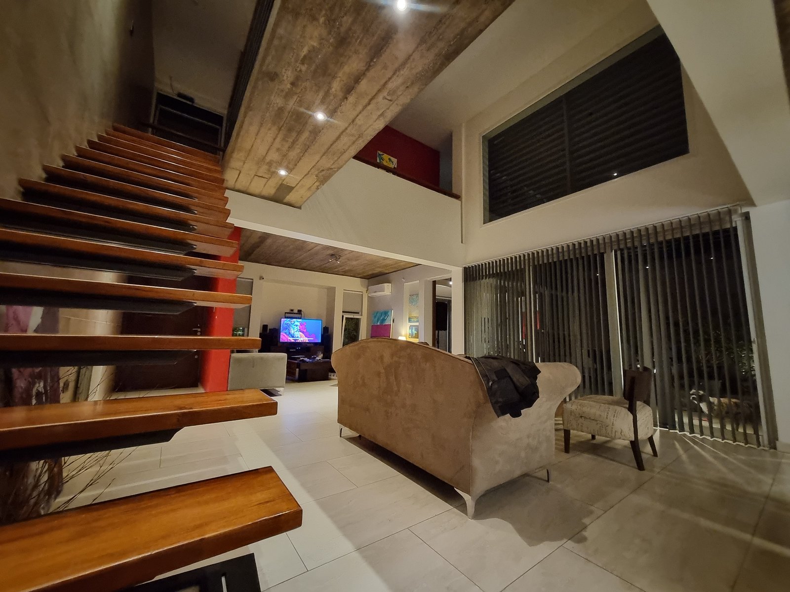 Living moderno con doble altura, escalera flotante y vigas expuestas — proyecto CASA ML , por ML ARQUITECTURA / ARQ. MARIANO LEOTTA, en J5400 Concepción