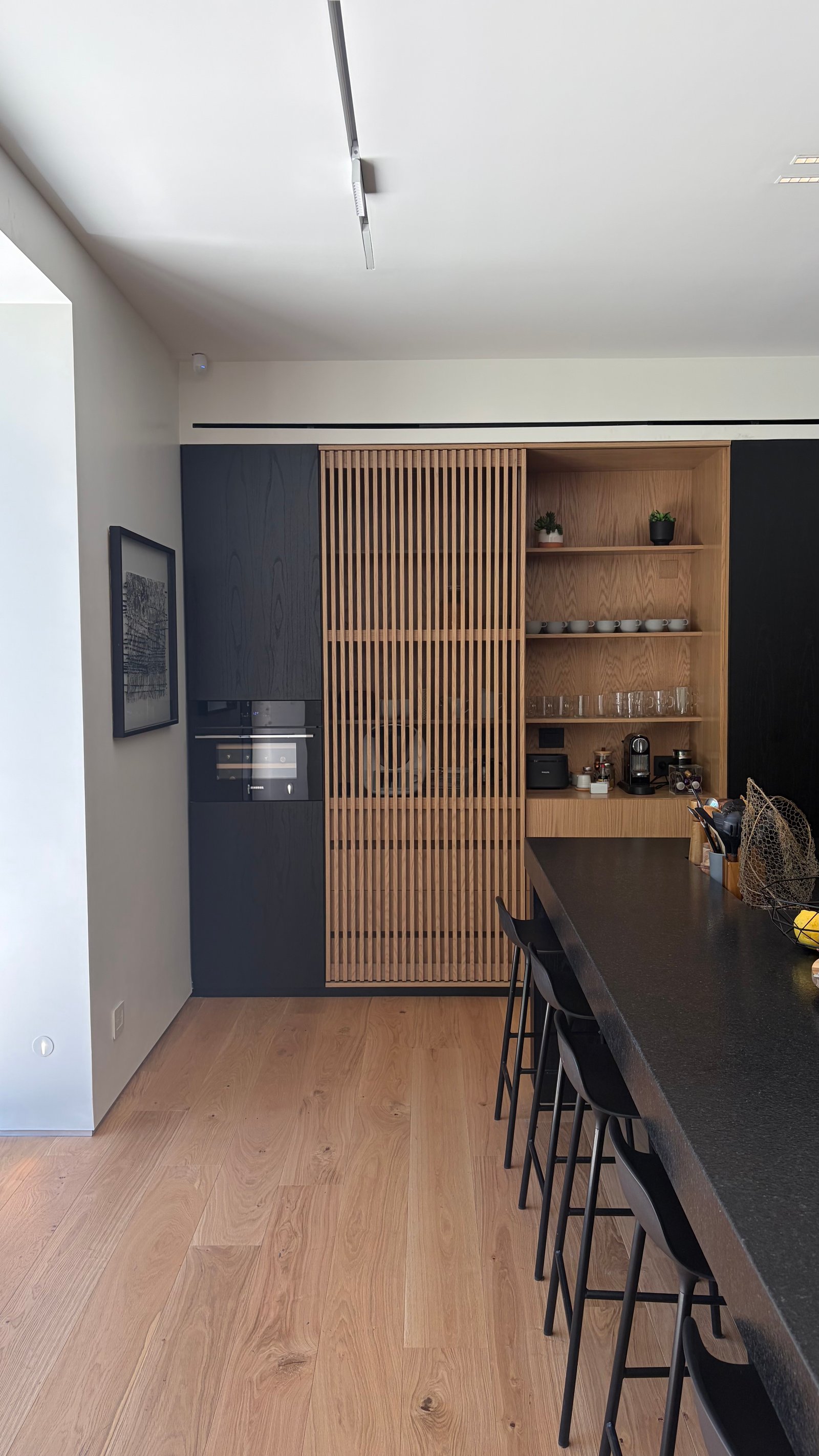 Cozinha moderna de madeira com portas ripadas e balcão — projeto Casa JCP, por radovic_arquitecto, em José C. Paz 850