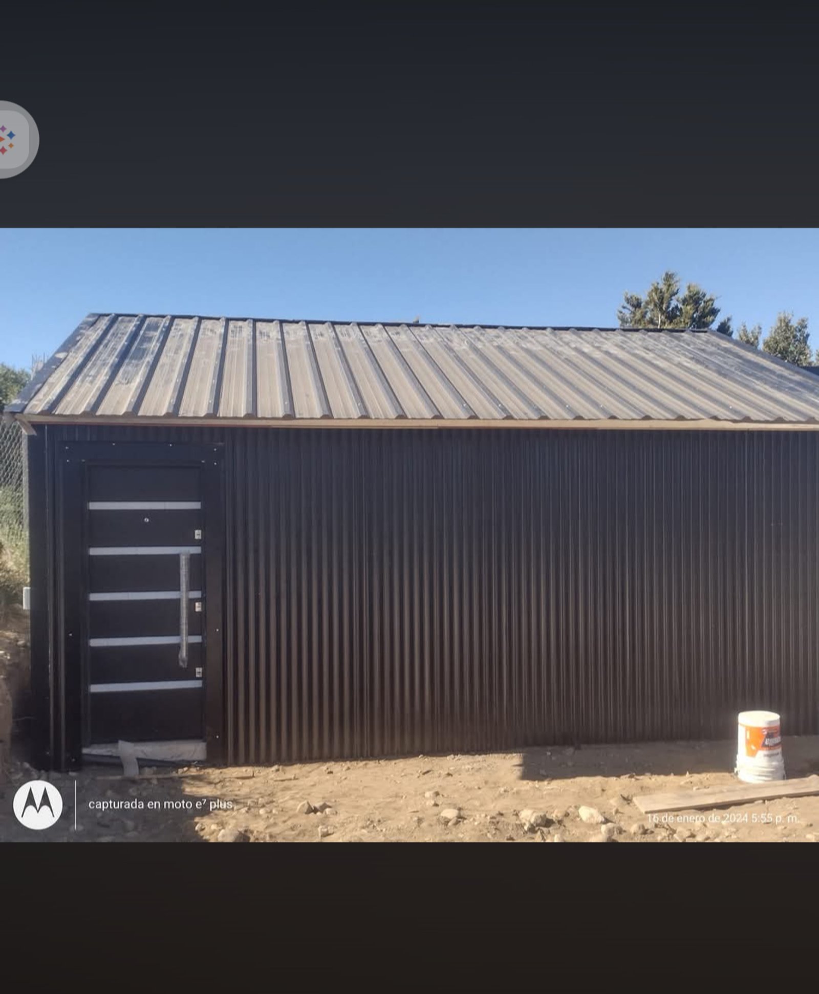 fachada moderna de galpón con puerta oscura — proyecto Depósito y taller en lomas de cauquen, por LP reformas y refacciones , en San Carlos de Bariloche