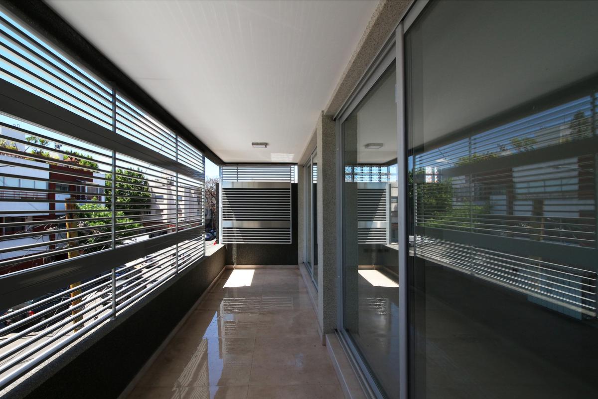 Varanda moderna com vista urbana e lambris de madeira — projeto Cañada de Gomez 1277, por BARBALACO ARQUITECTOS, em Buenos Aires