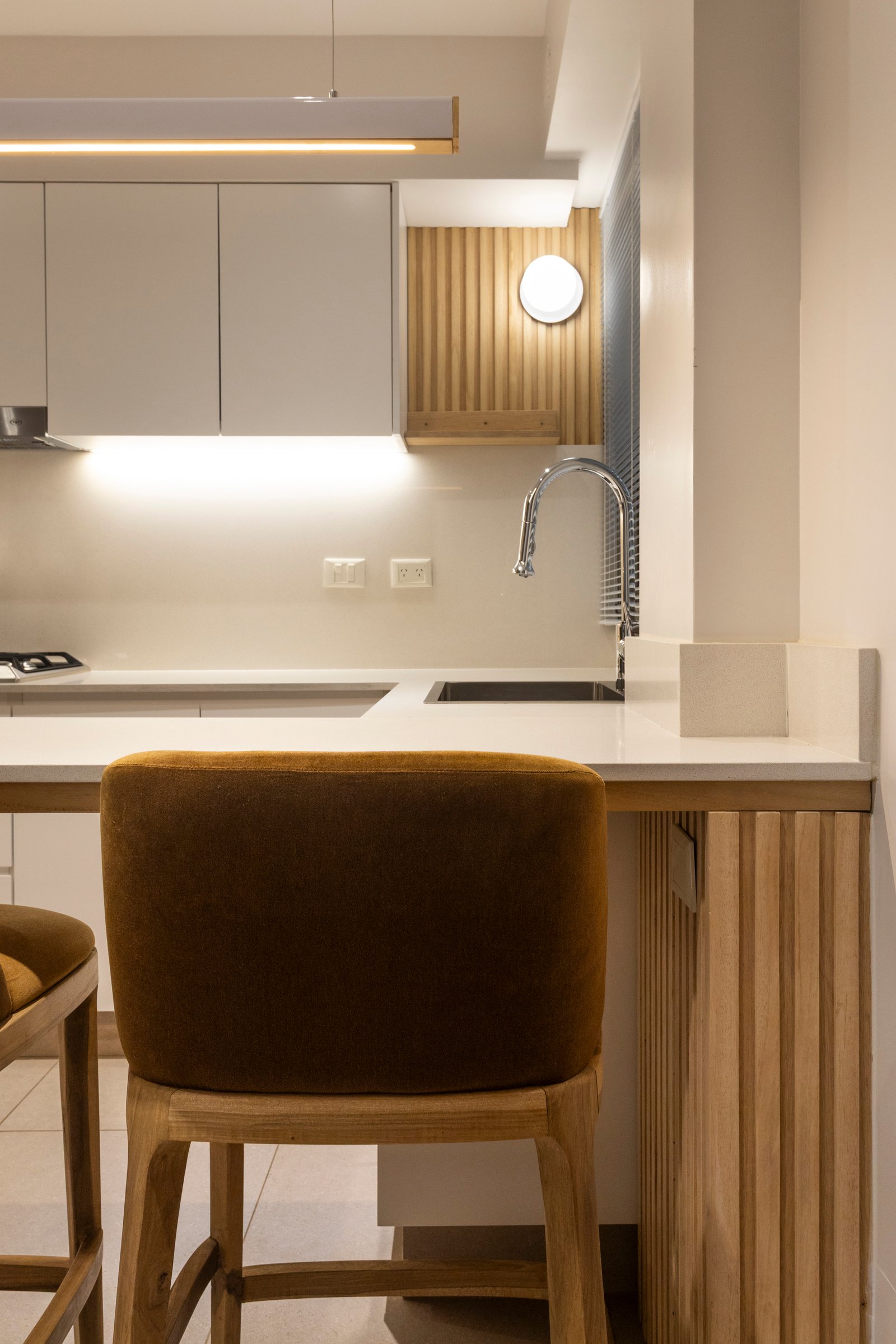 Cocina moderna con barra de terciopelo y detalles en madera — proyecto BARRACAS, por La Nave Arq., en Barracas