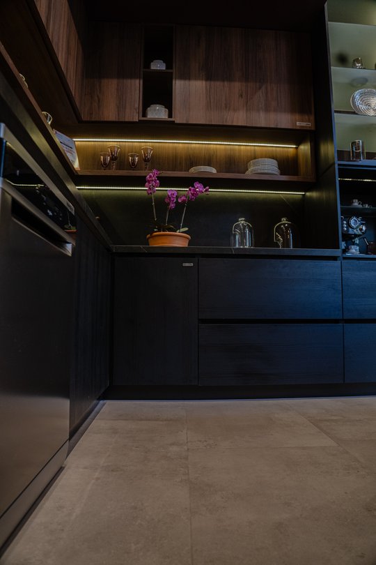 Cocina moderna con muebles de madera oscura y piso de piedra — proyecto Cocina | Casa DIR 2024, por San Lorenzo Design, en San Salvador de Jujuy