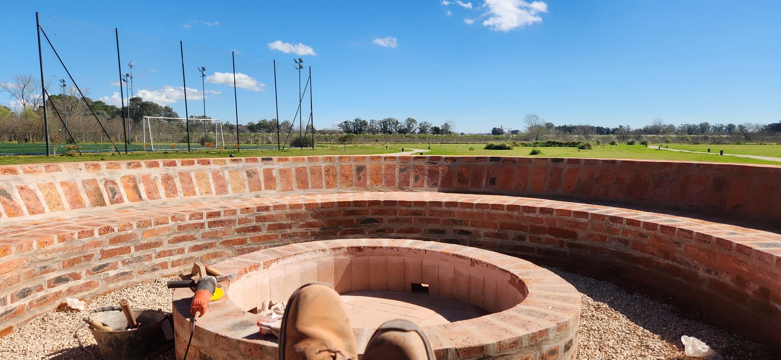 asiento curvo de ladrillo en construcción con vista al campo — proyecto Casa COAL, por Estudio Rifahi, en B2814 Los Cardales