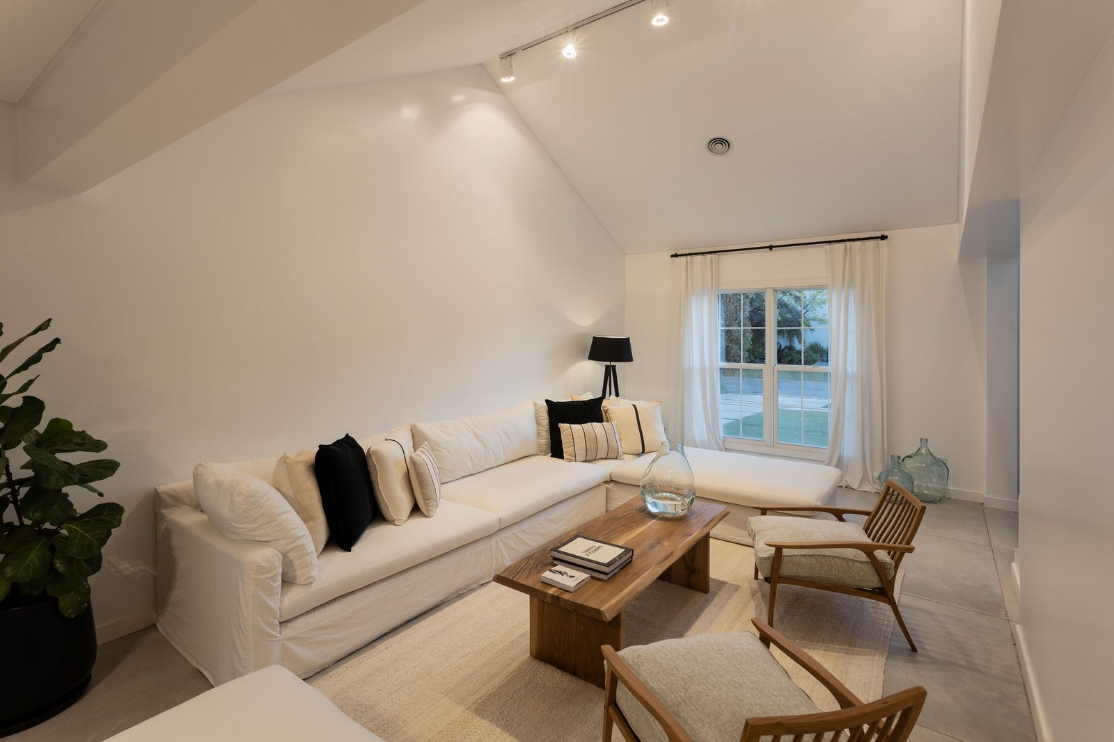 Living moderno con sofá seccional beige y detalles en madera — proyecto REFORMA GDLT, por Rastro Estudio, en Nordelta