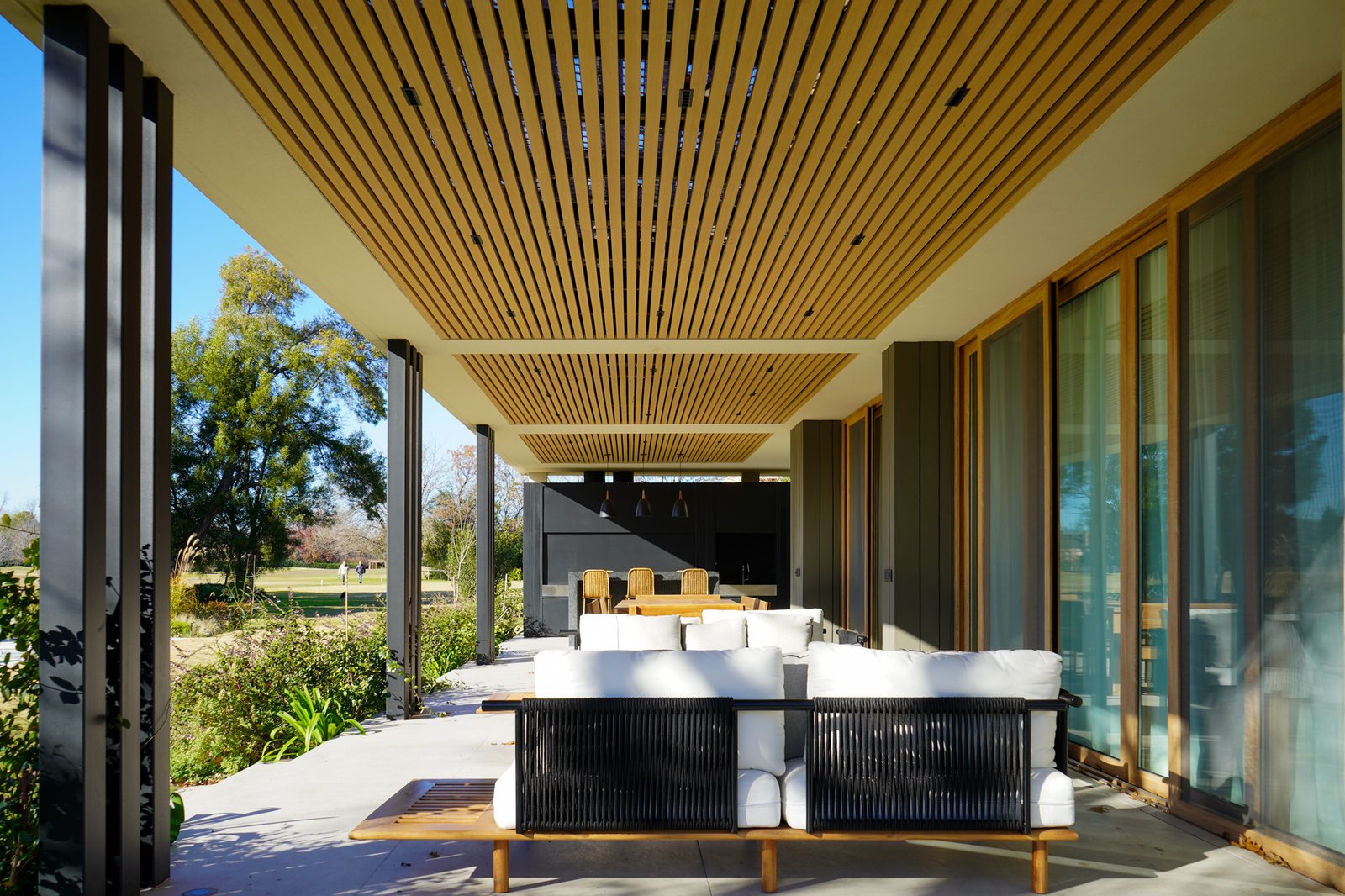 Patio moderno con techo de listones de madera y entorno rural — proyecto Obra Torterola, por lifecycle, en Provincia de Buenos Aires