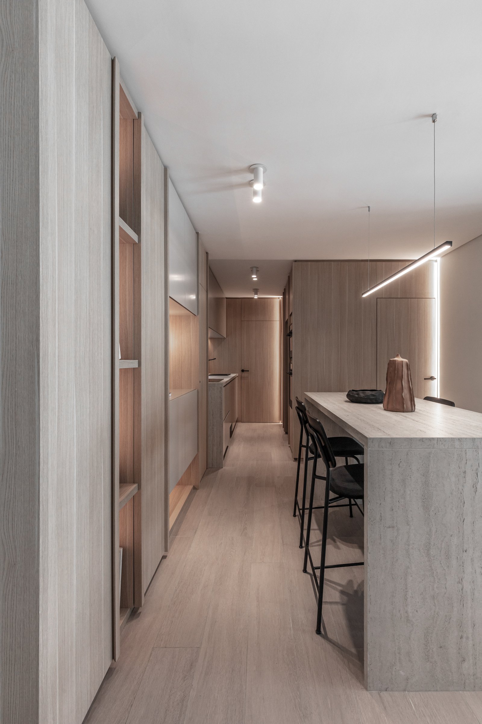 Cozinha moderna com ilha de pedra e painéis de madeira — projeto Eslovenia | Pied-à-terre | Lucia Quinteros, por Ren Studio, em Cdad. Autónoma de Buenos Aires