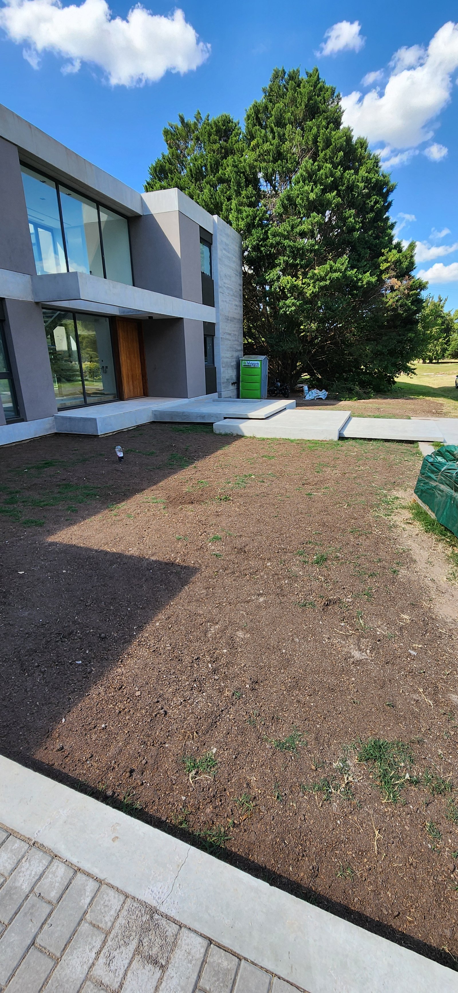 Fachada de casa moderna com grandes janelas e jardim — projeto Casa CAD, por Estudio Rifahi, em Moreno