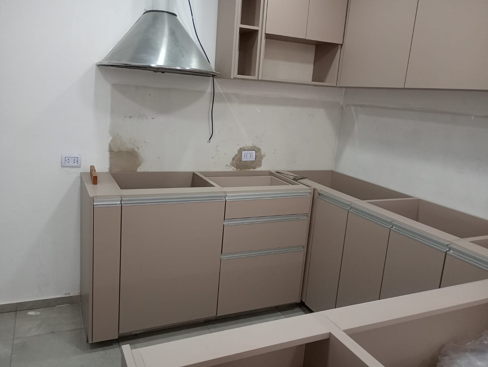 Cocina moderna en instalación, gabinetes beige y campana de acero inoxidable — proyecto Proyecto CL, por D'Agostina , en José C. Paz