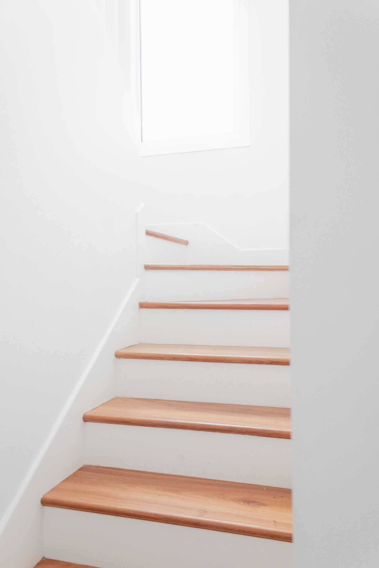 Escalera moderna minimalista con peldaños de madera natural — proyecto San Rafael, por Catalina Fitero Fotografìa, en Blvd. de Todos los Santos 3500