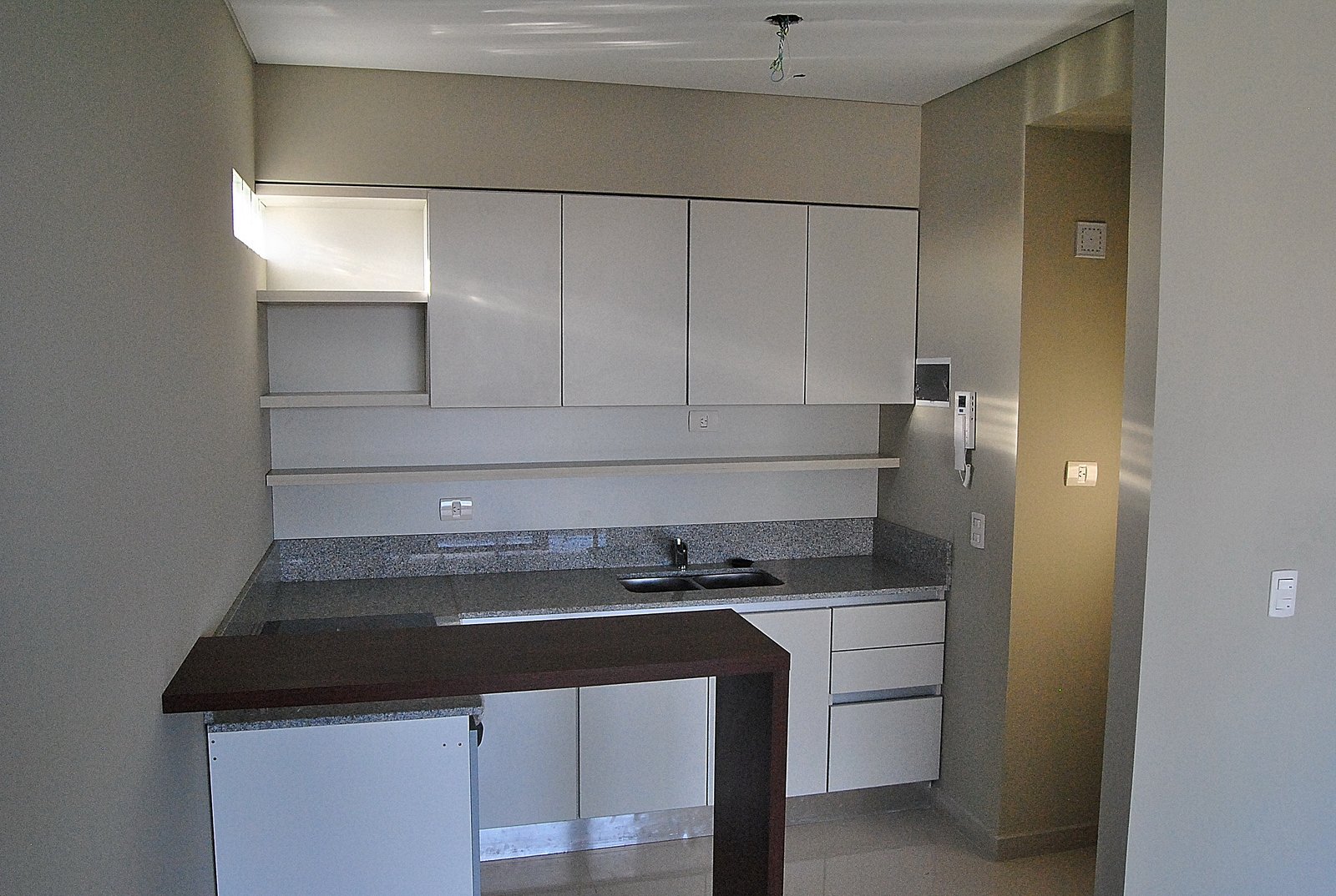 Cocina moderna minimalista con gabinetes blancos y encimera de piedra — proyecto Edificio San Martin, por LW Lopez Wolder arquitectos, en Av. S. Martín 5063