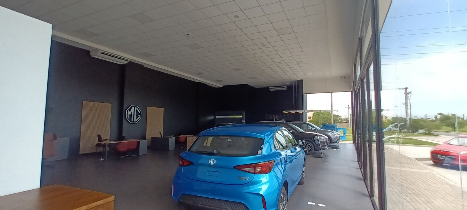 Interior de showroom de carros modernos com carros em exibição — projeto Locales Circunvalación Córdoba Norte, Indusplast Autocity, por Rojas Guri Arquitectos, em Córdoba