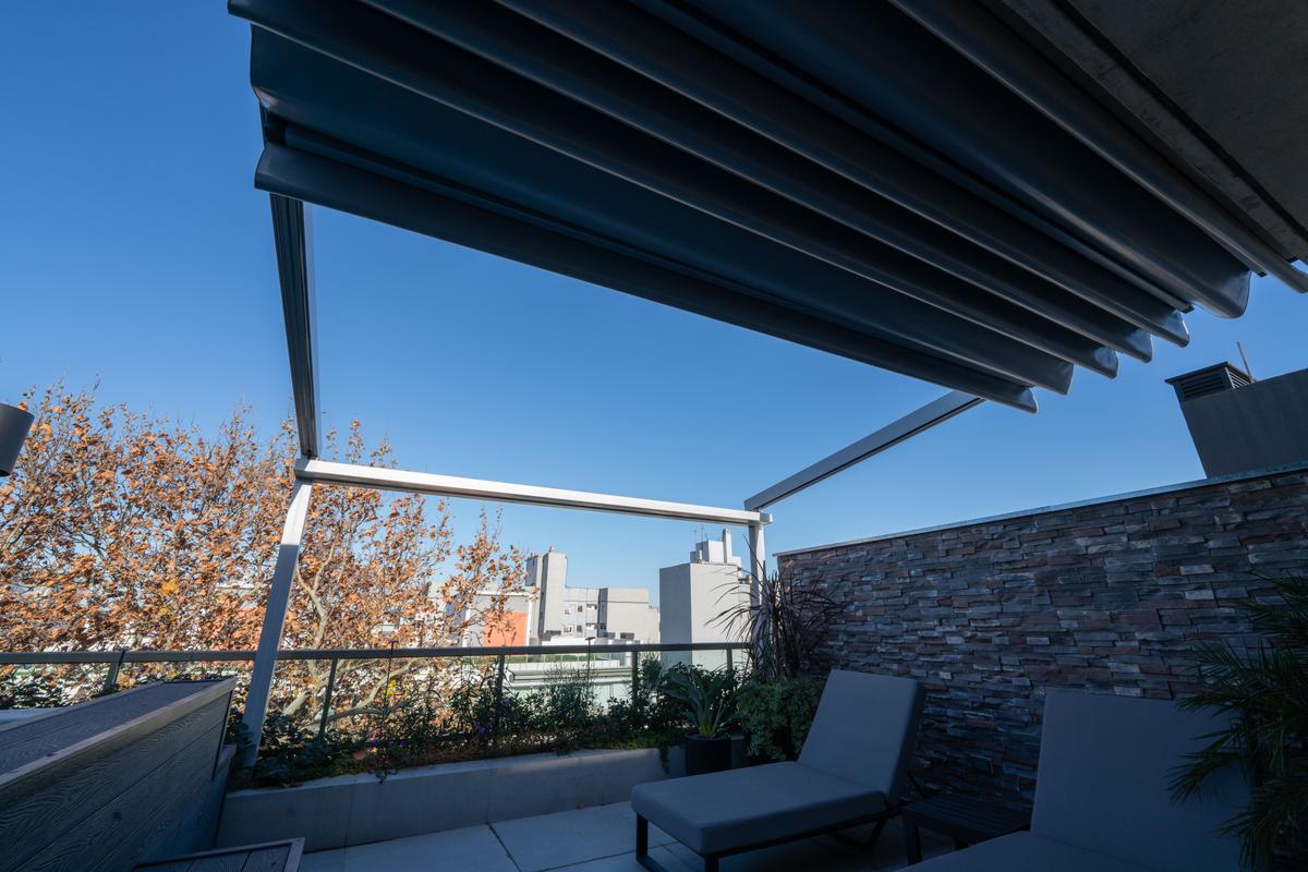 Terraço moderno com pergolado retrátil e vista urbana — projeto TOLDER - PERGOLAS, por Argentina en Obra 2024, em Rincón de Milberg