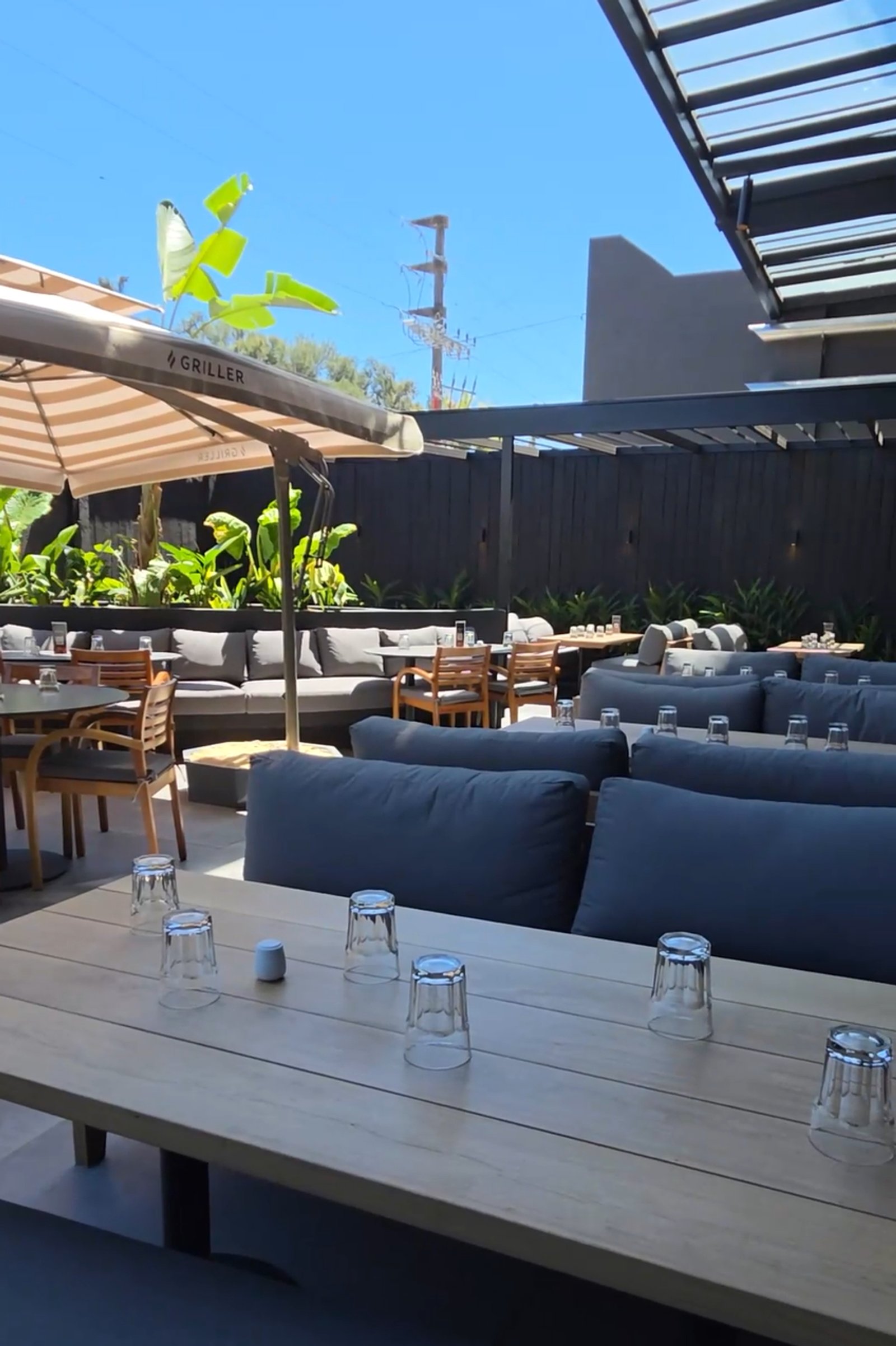 terraza de restaurante moderno con sofás grandes y pérgola — proyecto GRILLER - Restaurante, por GALPON OSUNA, en Canning