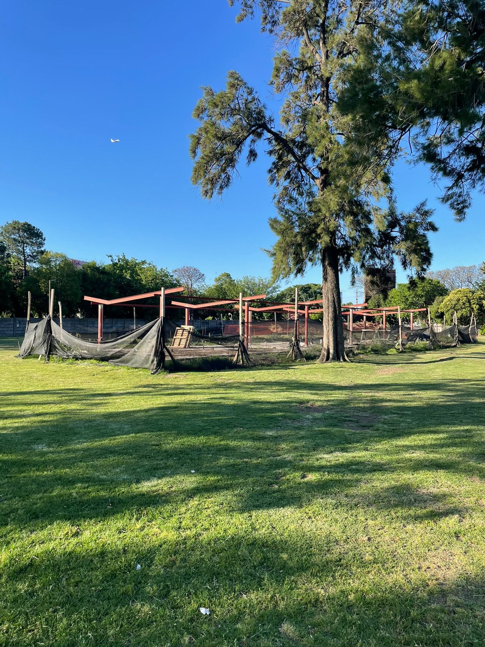 Área de parque com estruturas de rede e árvores grandes — projeto Parque Público Villa Adelina, por Estudio Rifahi, em B1607 Villa Adelina
