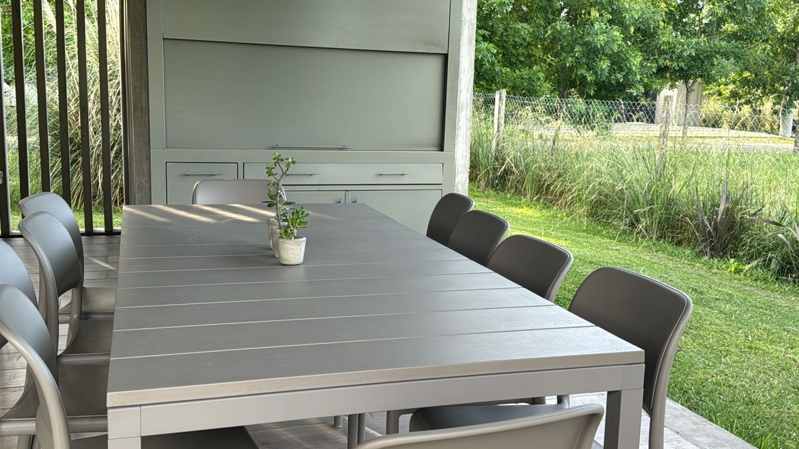 Comedor exterior moderno con mesa y sillas grises — proyecto Comedor, por Casa Nuñez