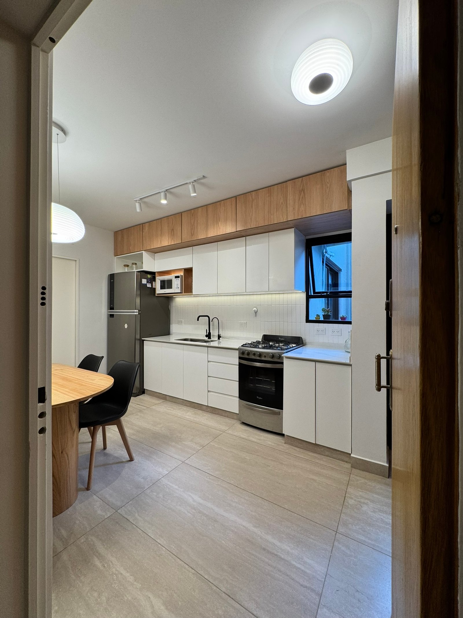 Cozinha moderna escandinava com mesa redonda de madeira — projeto Vera II, por MDBK Arquitectura, em Villa Crespo