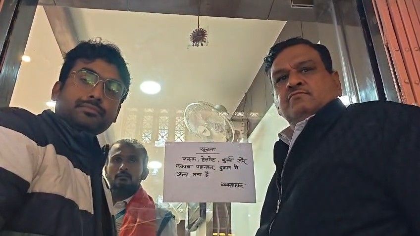 वाराणसी में आभूषण की दुकान के बाहर बुर्का, हेलमेट और मास्क पहनकर आने पर प्रतिबंध संबंधी पोस्टर