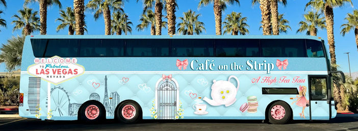 Light-blue double-decker tour bus on the Las Vegas Strip under palm trees, decorated with high‑tea graphics — teapot, teacup, macarons, skyline and welcome sign.
