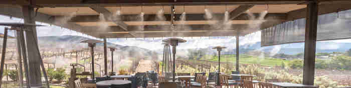 High-pressure misting over a restaurant patio and resort dining area
