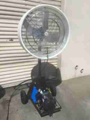 A 30″ “Work Zone” Misting Fan outside a closed white shop shutter