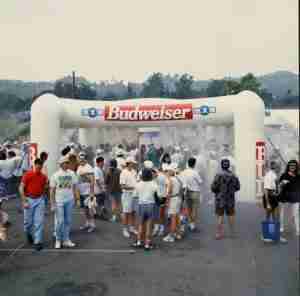 People standing under High Pressure 20' X 20' misting inflatable in a budweiser sponsored mathon.
