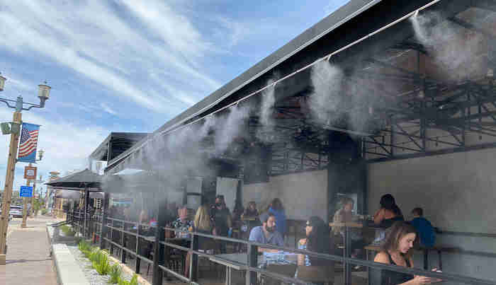 Misting cooling an outdoor pergola and pool lounge area