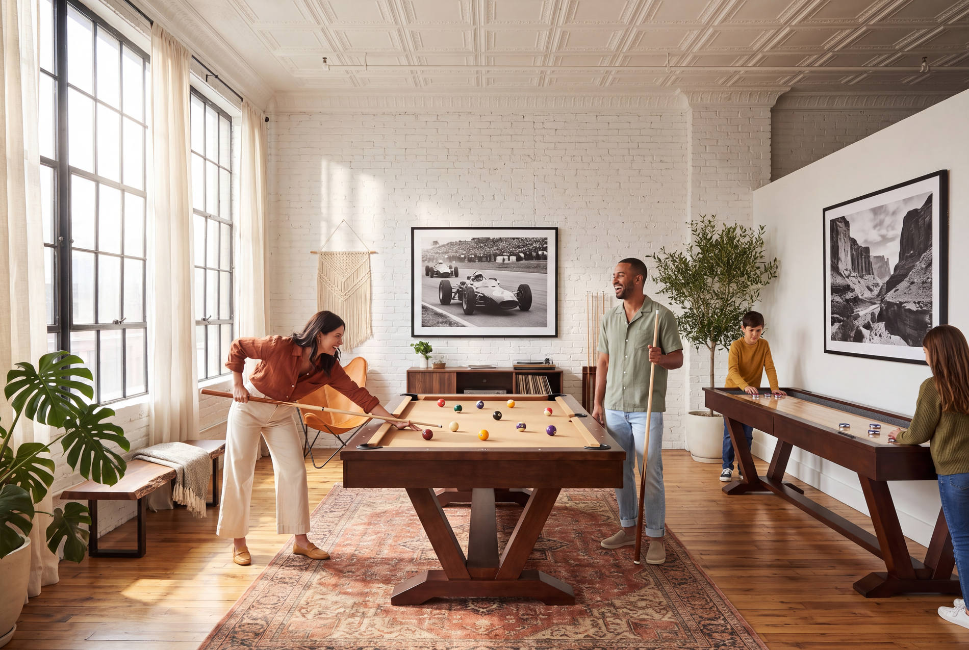 A family playing pool and shuffleboard in a bright loft game room