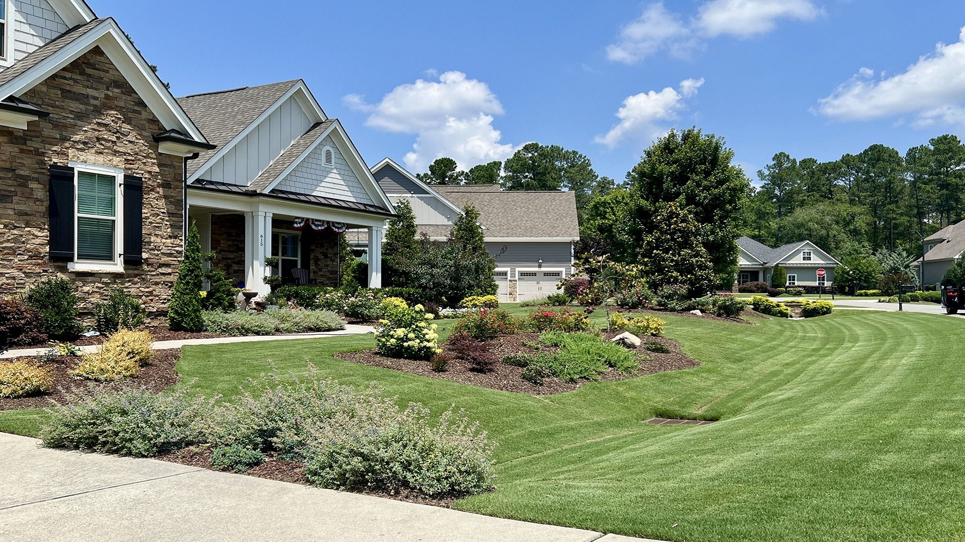 Perfectly manicured lawn and clean landscaping beds fronting a residential home