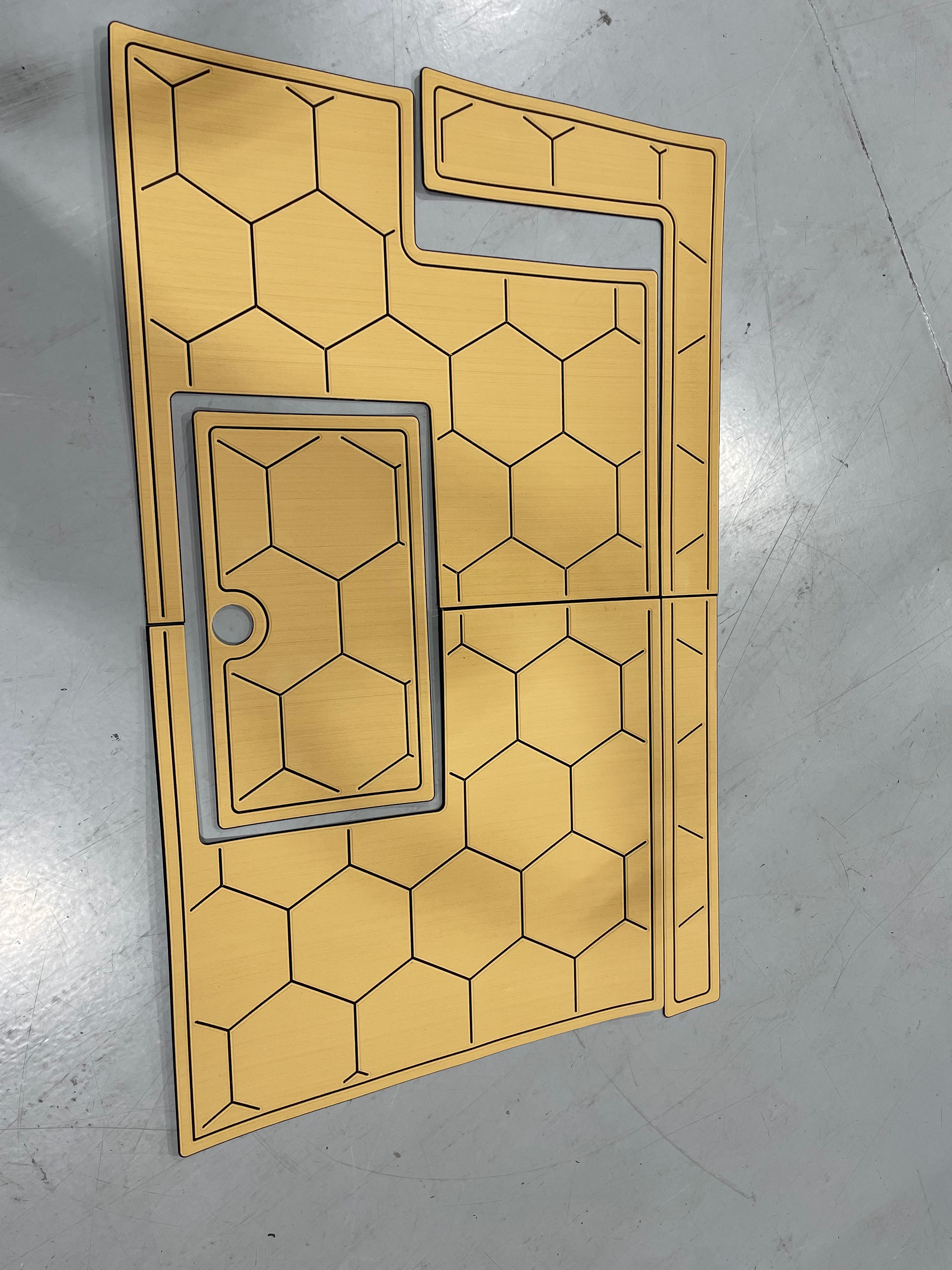 Custom-cut tan hexagonal marine flooring kit laid out pre-installation