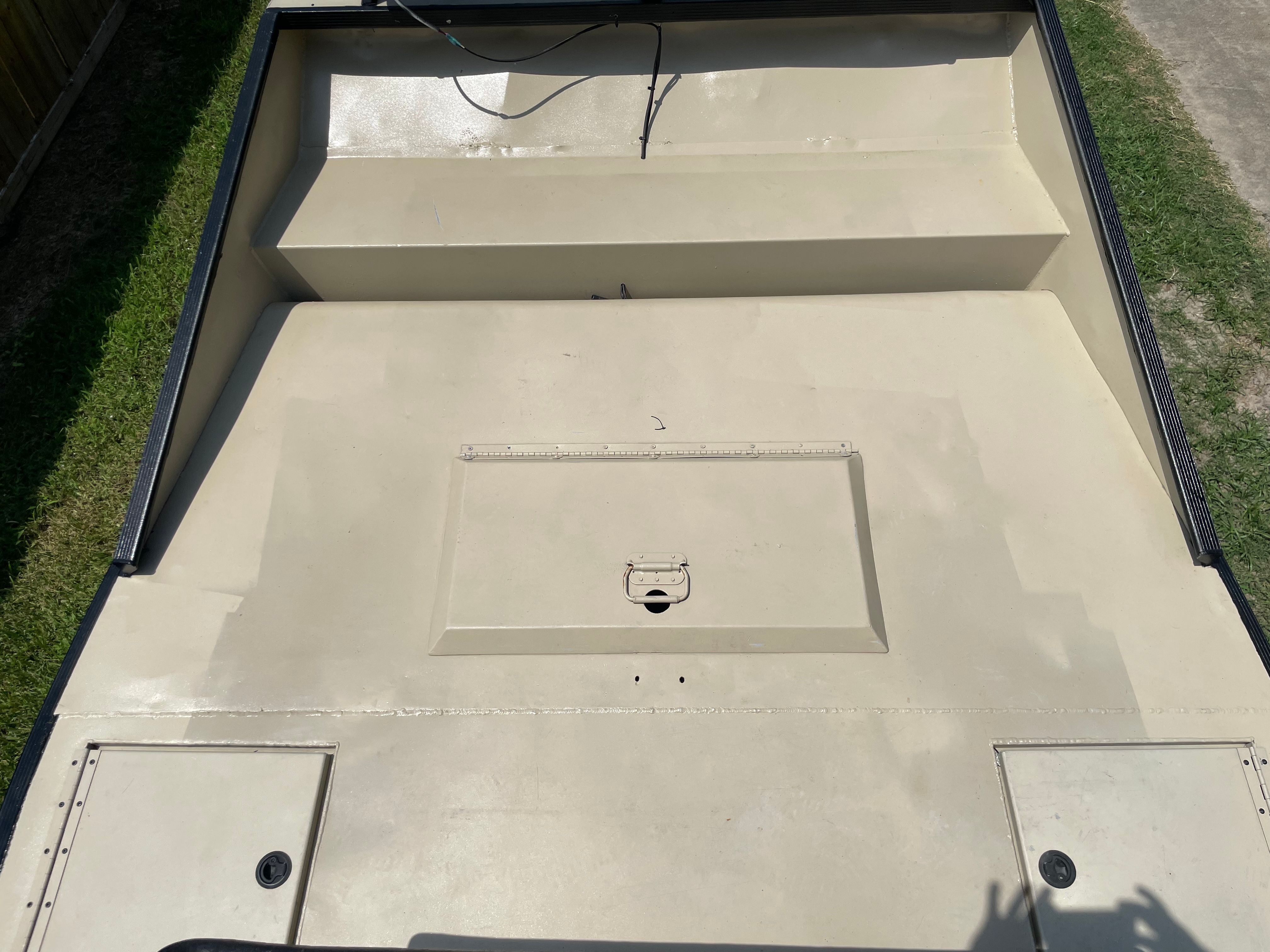 Tan-painted airboat deck with flush-mount storage hatches
