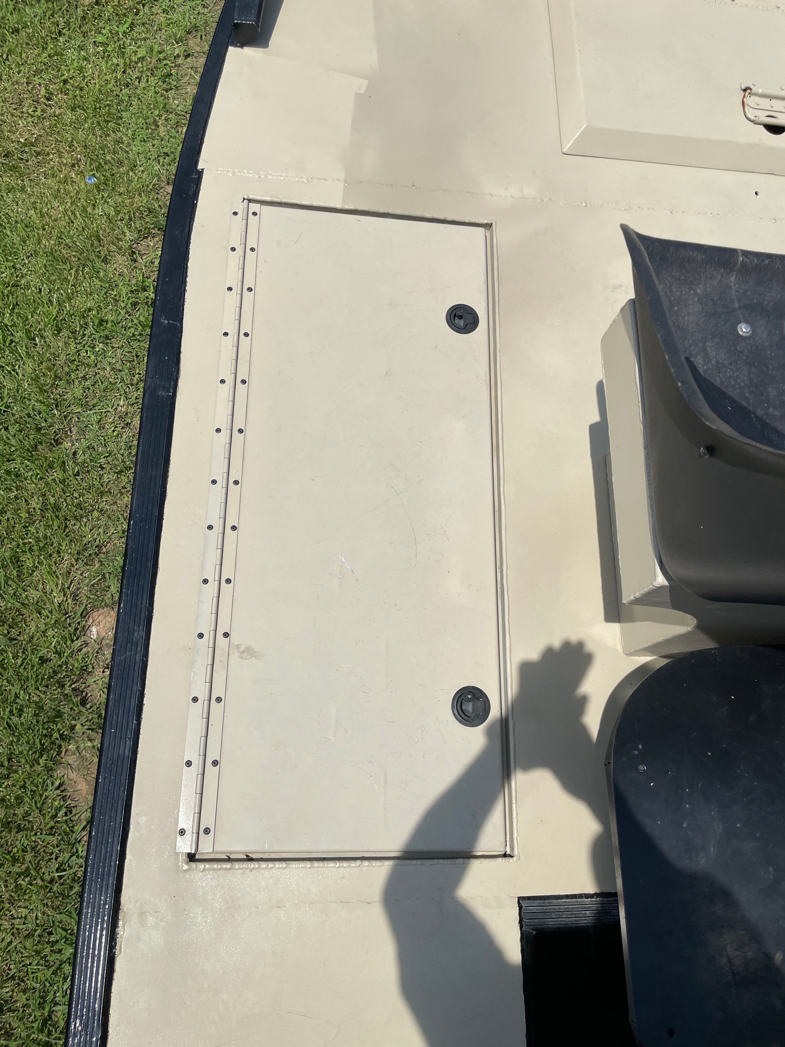 Flush-mount storage hatch detail on tan airboat deck