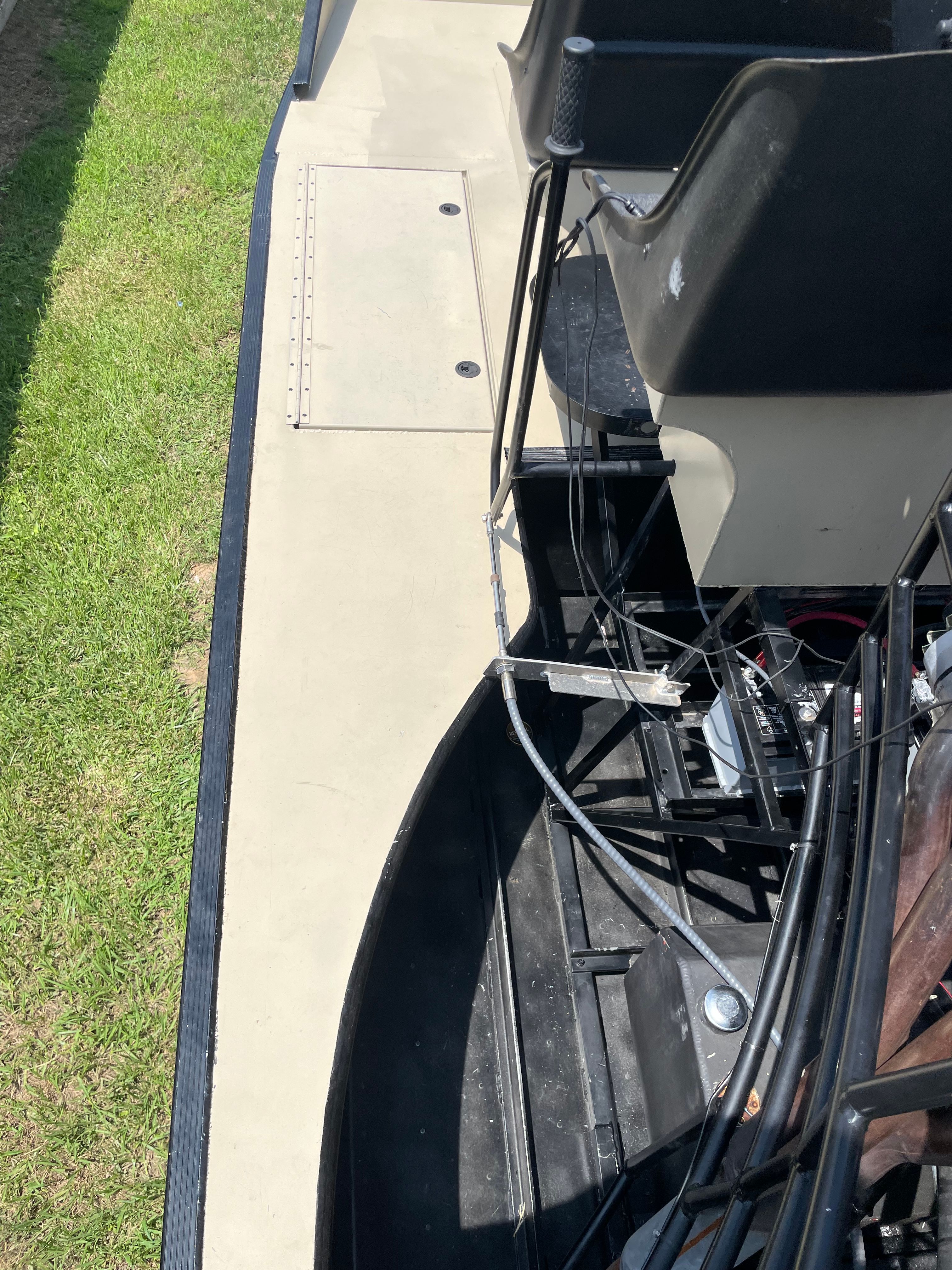 Airboat interior — dual bucket seats, controls, and tan deck walkway