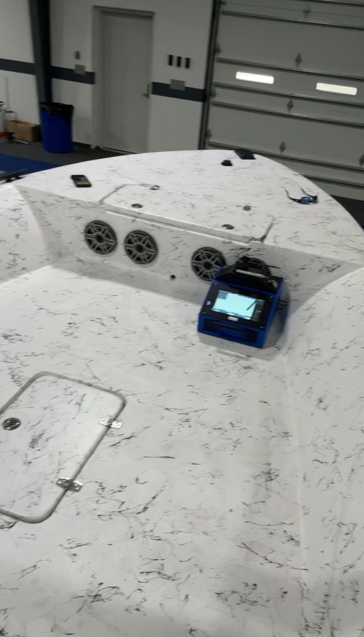 Custom white marbled marine flooring with integrated speakers on skiff