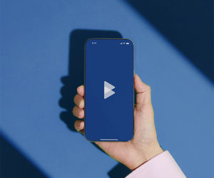 Hand hält Smartphone auf blauem Hintergrund