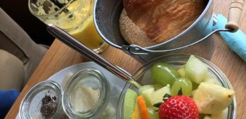 Leckeres Frühstück im Café Juli. Man sieht ein Croissant, Früchte und diverse Brotaufstriche