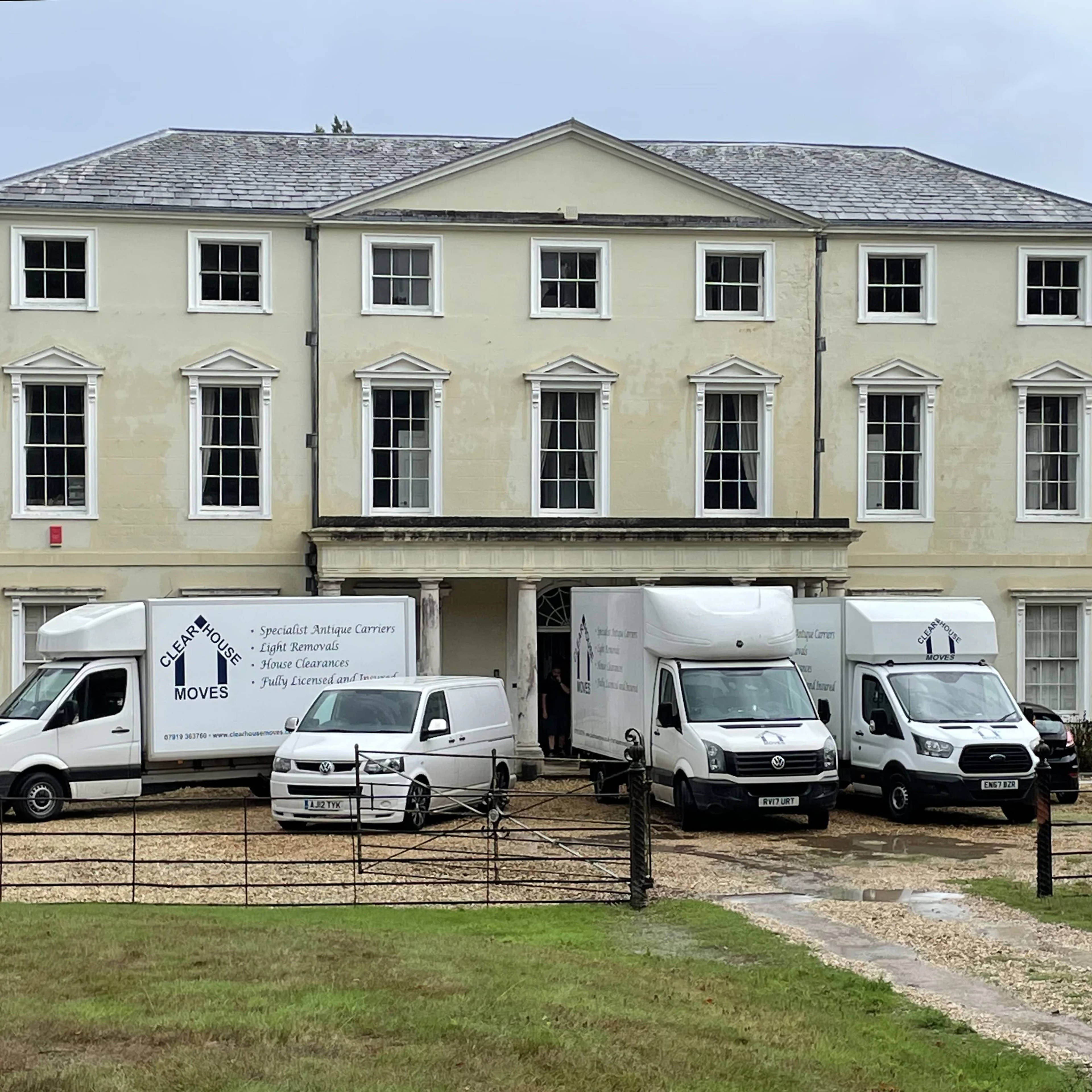 The Clear House Moves fleet of branded removal vans at a country house