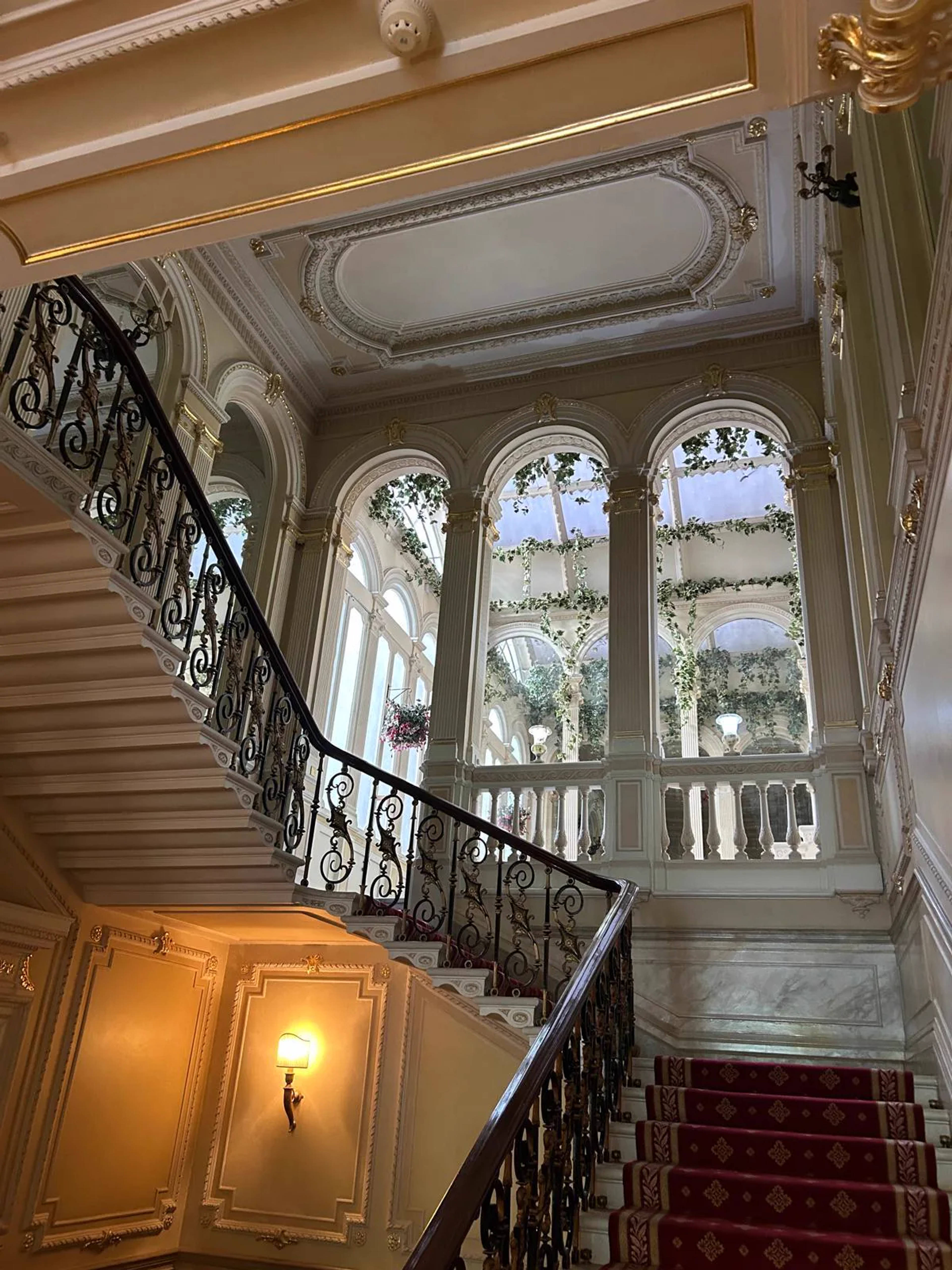 A grand carpeted staircase inside a period property