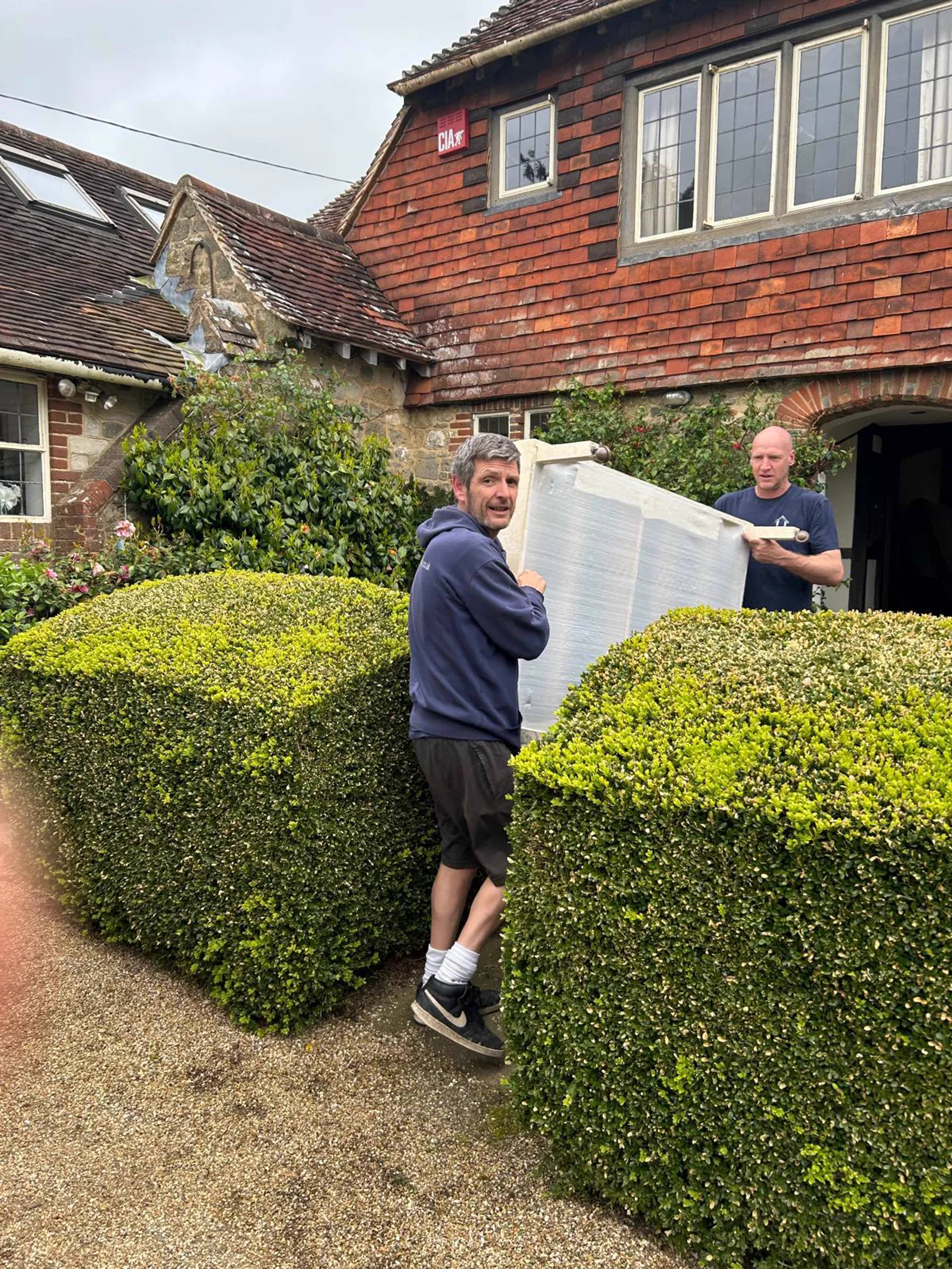 The friendly Clear House Moves team carrying an item from a country home