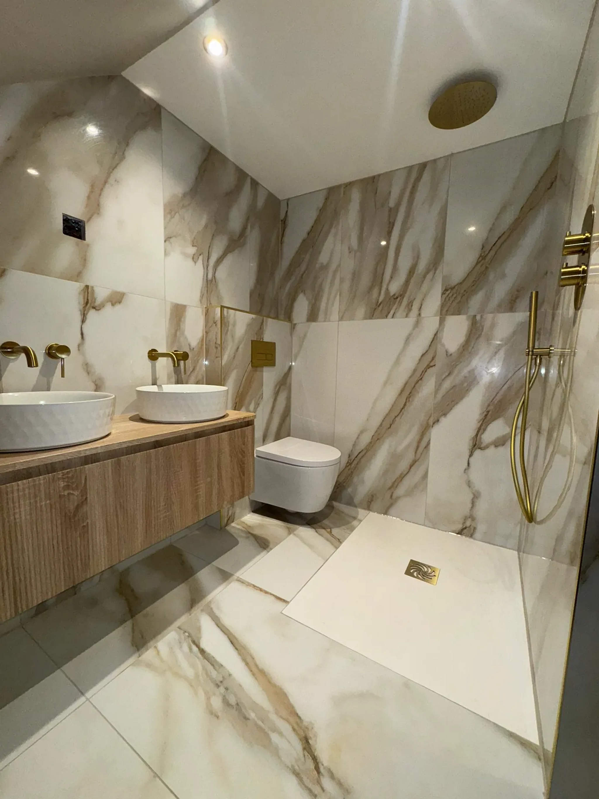 Marble bathroom with oak vanity, twin round basins, brass fittings and walk-in wet-room shower