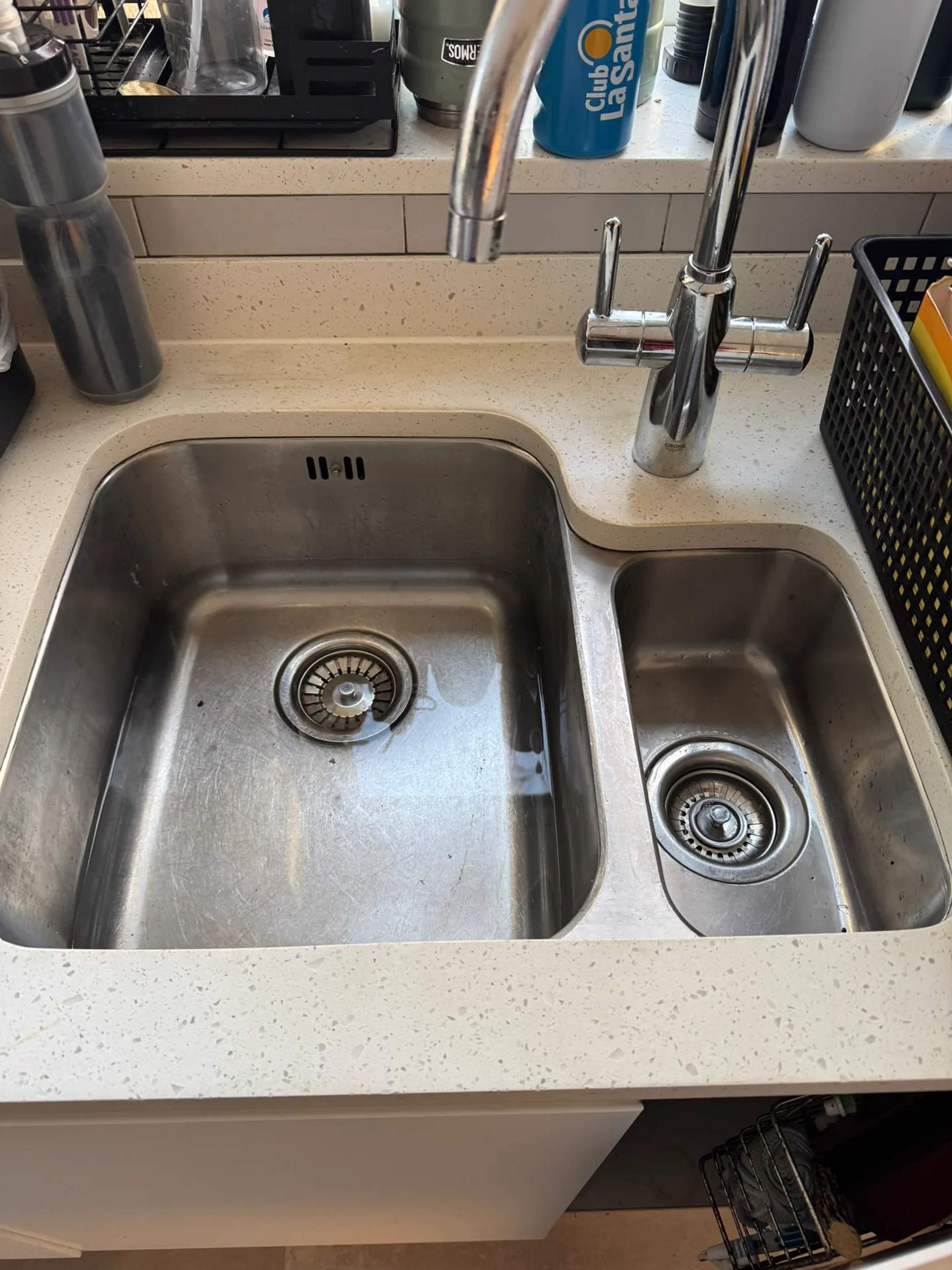 Stainless steel one-and-a-half bowl undermount sink with chrome mixer tap on speckled worktop