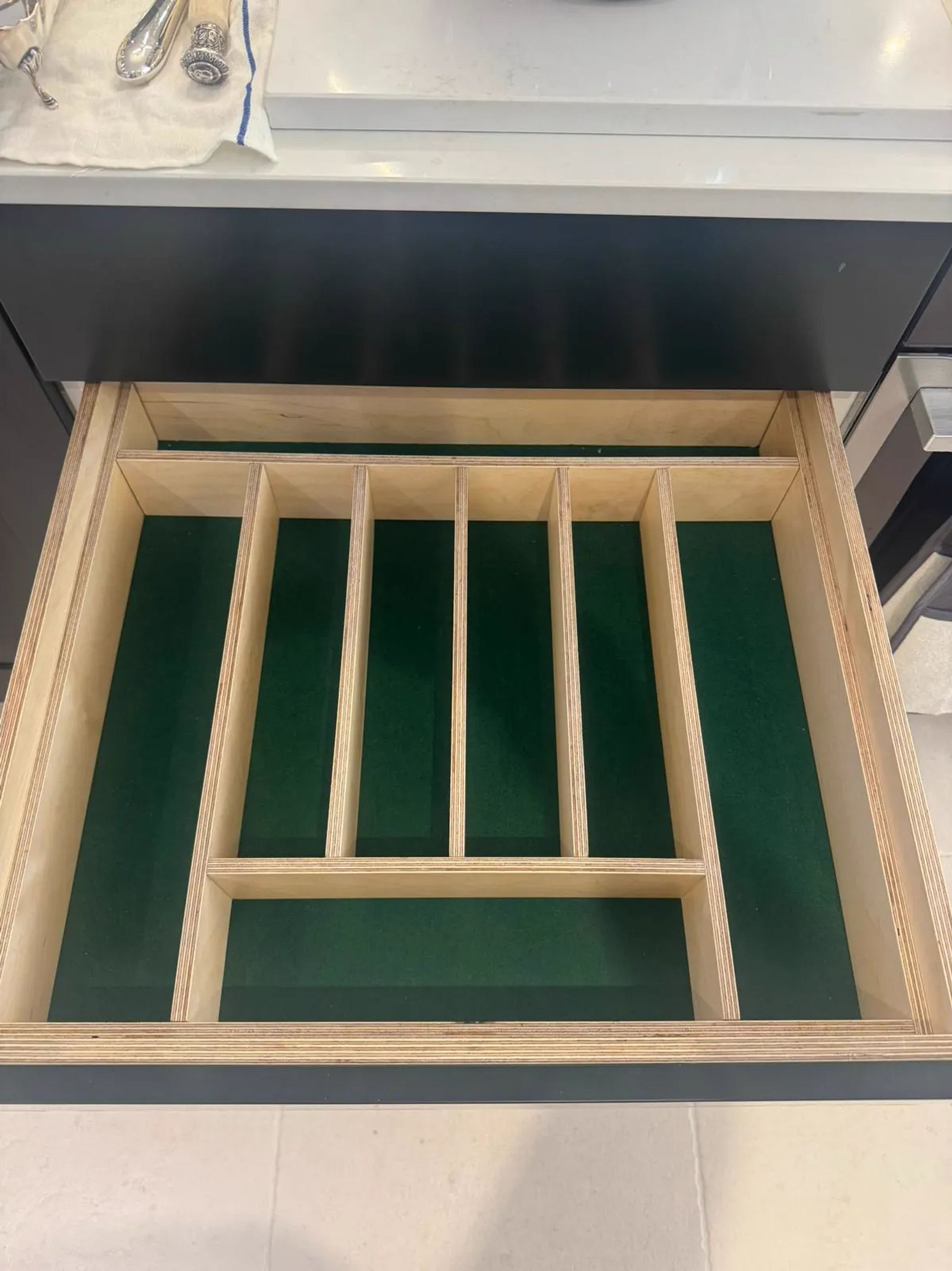 Birch plywood cutlery drawer insert with green felt lining in a kitchen unit
