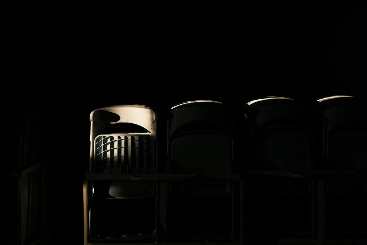 A row of empty chairs in a dark room